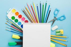 An album for drawing and creativity for school with stationery, a palette of colored paints, markers, brushes and pencils. photo