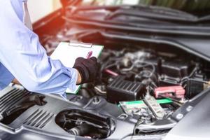 problema de la lista de comprobación técnica del coche en papel blanco con el concepto de servicio de sala de máquinas en el taller foto