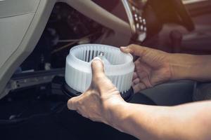 técnico en el centro de servicio quita y mantiene el aire del ventilador del automóvil, concepto de servicio foto