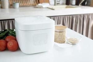 Electric rice cooker on wooden counter-top in the kitchen photo