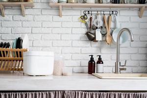 Electric rice cooker on wooden counter-top in the kitchen photo