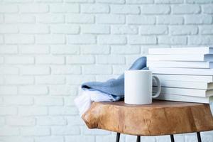 stack of white blank books for mockup and white mugs on wooden modern table photo