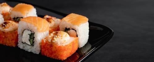 juego de rollos de sushi filadelfia en plato negro. sirviendo comida japonesa en el restaurante. foto