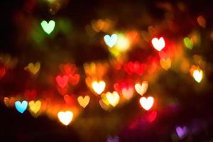 Multi-colored lights in shape of hearts. Blurred bokeh background photo