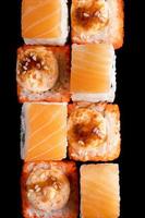 Set of Philadelphia sushi rolls on black plate. Serving Japanese food in restaurant. photo