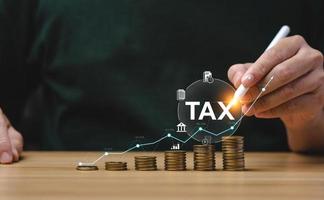 Tax deduction planning concept. Expenses, account, VAT, income tax, and property tax, pay tax. Businessman's hand and pile of coins on the table. photo