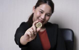 mujer de negocios sosteniendo el concepto de intercambio de criptomonedas de bitcoins. tecnología e inversión digital. financiar, comerciante, inversor, oro bitcoin efectivo, recaudar dinero foto