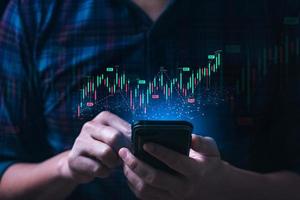 Business man or trader showing a virtual trading chart on a smartphone. planning and strategy, Stock market, Business growth, progress or success concept. financial graph bar candlestick photo