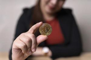 mujer de negocios sosteniendo el concepto de intercambio de criptomonedas de bitcoins. tecnología e inversión digital. financiar, comerciante, inversor, oro bitcoin efectivo, recaudar dinero foto