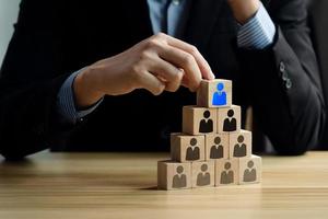 HRM or Human Resource Management. Businessmen planning on manpower or HR Planning. strategy of human resource management, select icon Manager for human development on wooden block. Workers, employees photo