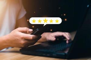 Customer satisfaction concept. Man hand using smartphone with five star pop-up icon for feedback. with copy space. 5 star satisfaction, Excellent business rating experience photo