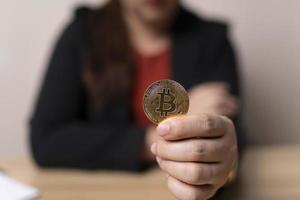 mujer de negocios sosteniendo el concepto de intercambio de criptomonedas de bitcoins. tecnología e inversión digital. financiar, comerciante, inversionista, efectivo, recolectar dinero, alto riesgo de inversión foto