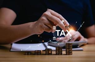 Tax deduction planning concept. Expenses, account, VAT, income tax, and property tax, pay tax. Revenue Department. Individuals calculate annual expenses and taxes. with a pile of coins on the desk photo