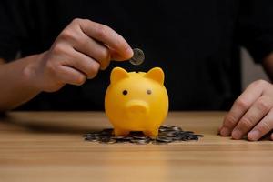 Businessman holding a coin in a piggy bank. money growth and saving money. Investment Balances, financial planning. Pension and retirement, tax photo