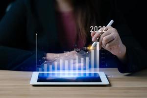 Business growth and progress concept. Businessman is showing virtual hologram chart from tablet. plans to increase business growth and an increase in the indicators of positive growth in 2022 photo