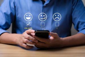 Customer satisfaction concept. Hands of a business man using a smartphone to comment 5 stars. Excellent business rating experience. Satisfaction Rating, good and impressive photo