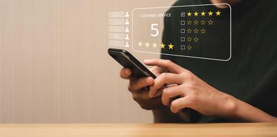 Customer satisfaction concept. Hands of business men using a mobile to comment 5 stars. Satisfaction Rating, good and impressive, after sales service. Excellent business rating, reputation photo