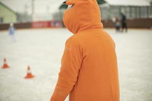 ropa naranja. animador en el estadio en invierno. patinaje sobre hielo. foto