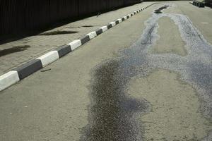 Painted road curb. Border marking with white and black paint. Street details. photo