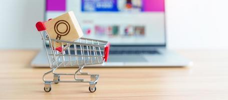 Shopping cart with Magnifying icon block and laptop computer with marketplace website, technology, ecommerce, SEO, Search Engine Optimization, Advertising, keyword and online payment concept photo