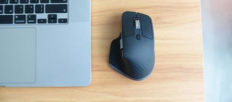 Ergonomic vertical mouse with laptop computer on adjustable desk at workplace, prevention wrist pain. De Quervain s tenosynovitis, Intersection Symptom, Carpal Tunnel or Office syndrome concept photo