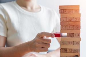 hand placing or pulling wooden block on the tower. Business planning, Decision, Risk Management, Solution and strategy Conceptual photo