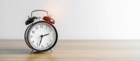 Vintage alarm clock on wooden table and copy space for text. Activity, daily routine, afternoon , workout and Work life balance concept photo