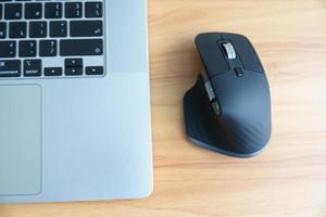Ergonomic vertical mouse with laptop computer on adjustable desk at workplace, prevention wrist pain. De Quervain s tenosynovitis, Intersection Symptom, Carpal Tunnel or Office syndrome concept photo