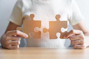 Hand connecting couple puzzle piece. Business Solving, mission, challenge, success, goals, target and strategy concepts photo