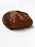 Black bread with sesame seeds on white background photo