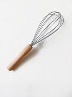 hand whisk for kitchen with wooden handle on white background photo