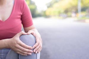 Running women with knee pain in the park photo