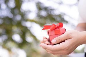 Gift box in hand for lovers on Valentine's Day, New Year, Christmas Day photo