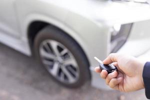 Salesman is carrying the car keys delivered to the customer at the showroom with a low interest offer. Special promotion photo