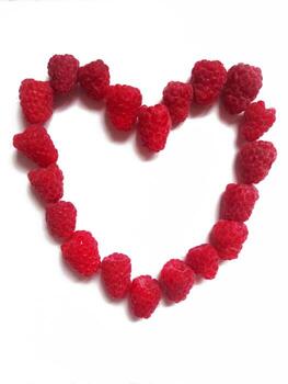 raspberry heart. The figure of the heart is lined with ripe raspberry berries on a white background. photo