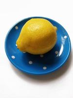 lemon on a blue plate on a white background photo