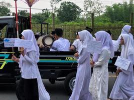 BLITAR, INDONESIA - October 21, 2022 Junior high school students from MTSN 5 Blitar are in a parade to commemorate Santri Day and the Birthday of the Prophet Muhammad photo