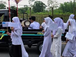 BLITAR, INDONESIA - October 21, 2022 Junior high school students from MTSN 5 Blitar are in a parade to commemorate Santri Day and the Birthday of the Prophet Muhammad photo