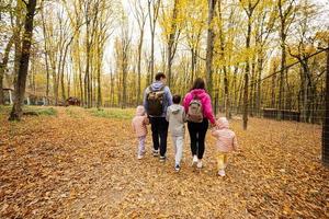 parte posterior de la familia con niños en un paseo por el bosque de otoño. foto