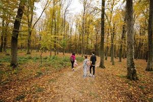 Mother with kids on a walk in autumn forest. photo