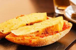 brocheta de tortilla de patata con pan con tomate. comida típica española. imagen horizontal foto