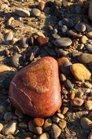 piedra en forma de corazón en la playa. imagen vertical foto