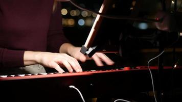 Woman plays a keyboard in a music recording studio video