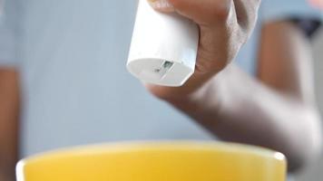 Handheld gadget pressed dropping material into bowl video