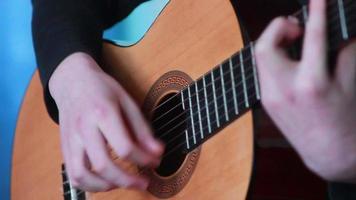 menselijk hand- spelen Aan de strings van de gitaar video