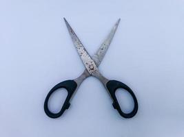 Rusty scissors with black handle photo
