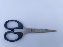 Rusty scissors with black handle photo