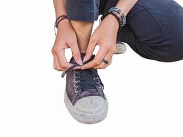 women are tying shoelaces isolated on a white background photo