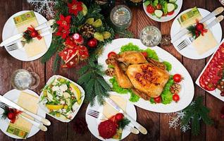 pavo o pollo al horno. la mesa navideña se sirve con un pavo, decorado con oropel brillante y velas. pollo frito, mesa. cena de Navidad. endecha plana vista superior foto