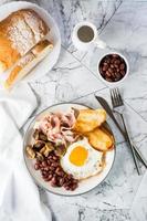 Traditional English breakfast with egg, bacon, beans, mushrooms and toast. Top and vertical view photo